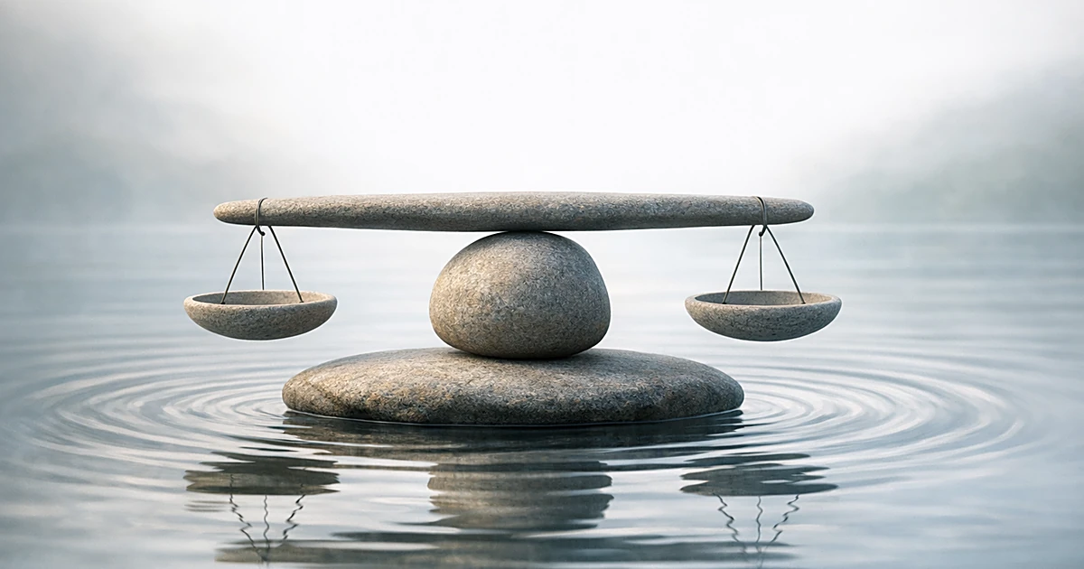 Abstract stone balance scales on calm water with gentle ripples in soft natural light